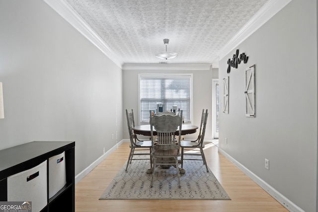 dining area with baseboards, crown molding, light wood-style flooring, and a textured ceiling