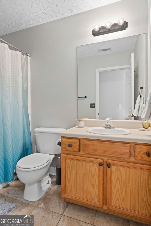 bathroom with a textured ceiling, toilet, a shower with shower curtain, vanity, and visible vents