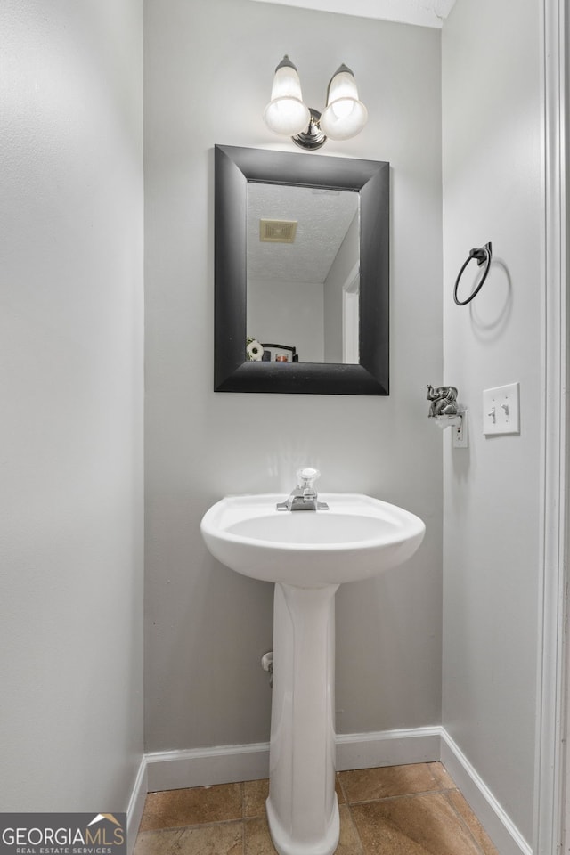 bathroom with baseboards and visible vents