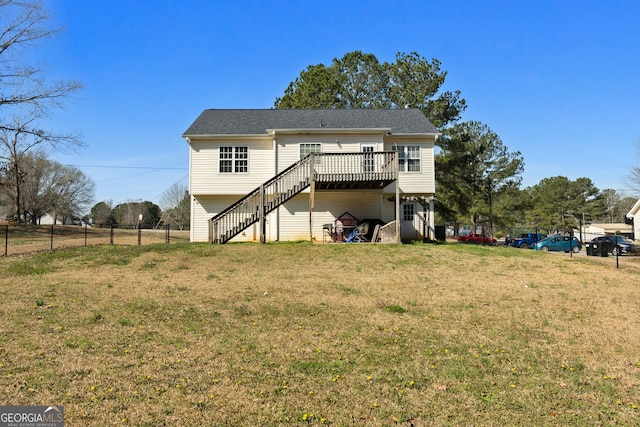 back of property with a deck, a lawn, stairway, and fence