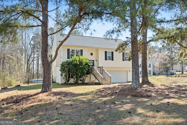 split foyer home featuring a garage, a trampoline, and a chimney