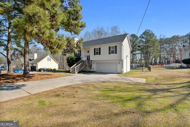 raised ranch with a garage, a front yard, and driveway