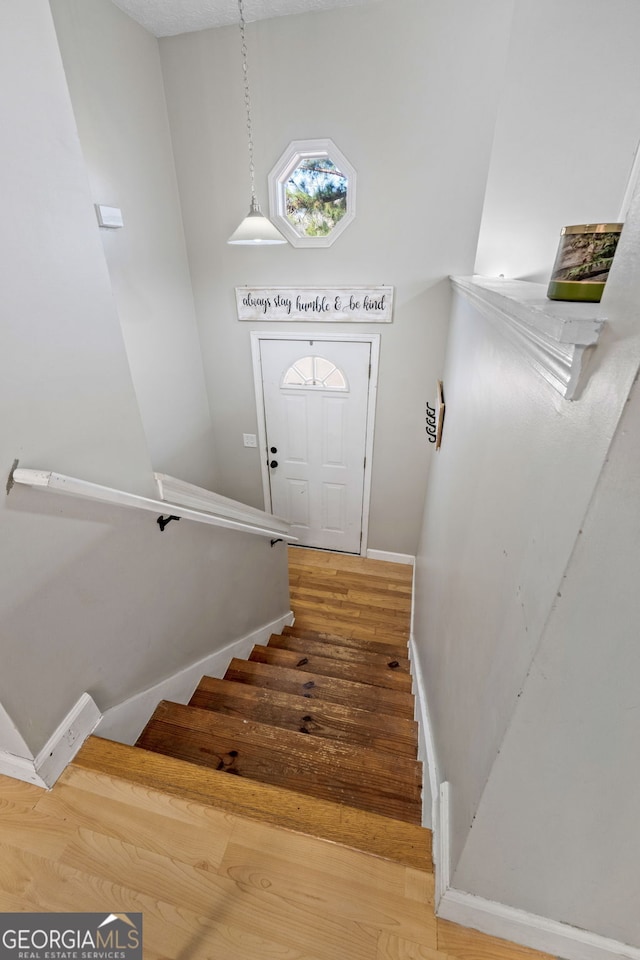 stairway with baseboards and wood finished floors