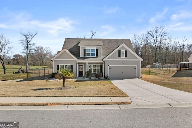 view of front of home with driveway, a front lawn, board and batten siding, and fence