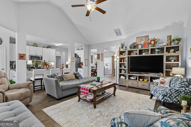 living area with ceiling fan, high vaulted ceiling, wood finished floors, and visible vents