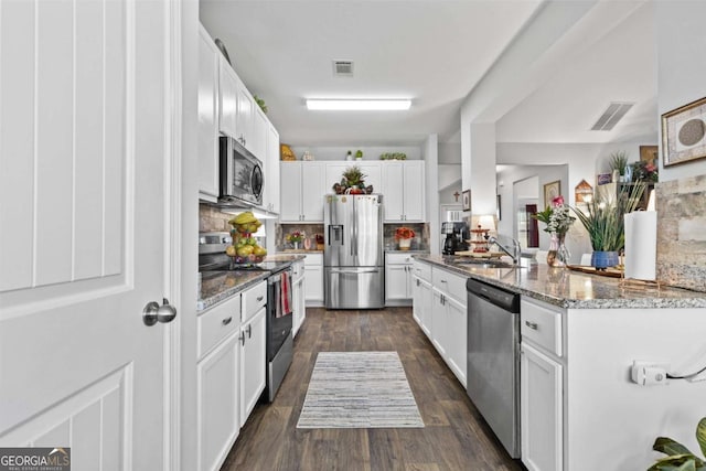 kitchen with stainless steel appliances, a sink, visible vents, and white cabinetry