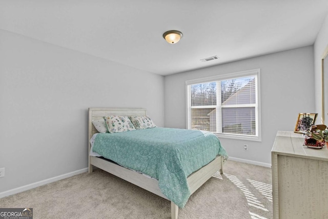 carpeted bedroom featuring baseboards and visible vents