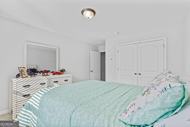 carpeted bedroom with a closet and baseboards