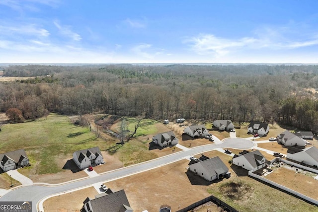 bird's eye view with a wooded view