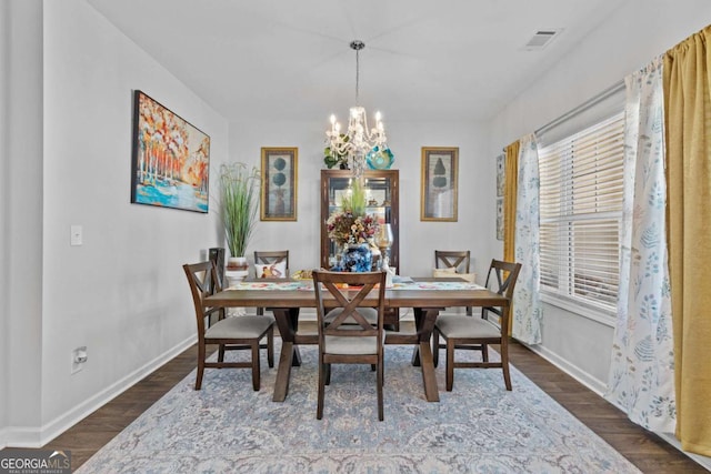 dining room with a chandelier, visible vents, dark wood finished floors, and baseboards