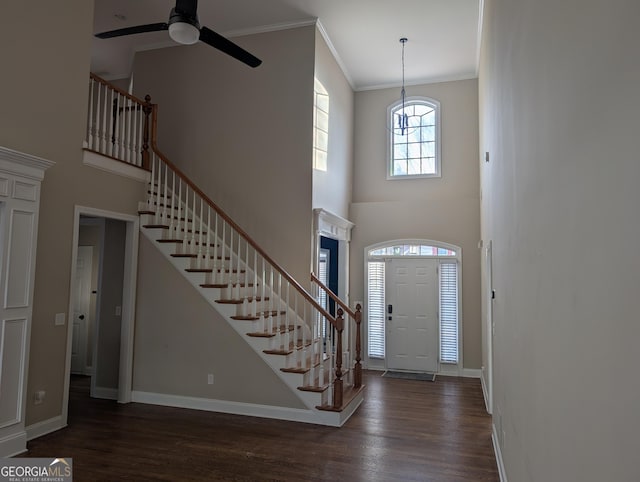 foyer with crown molding, stairs, and dark wood-type flooring