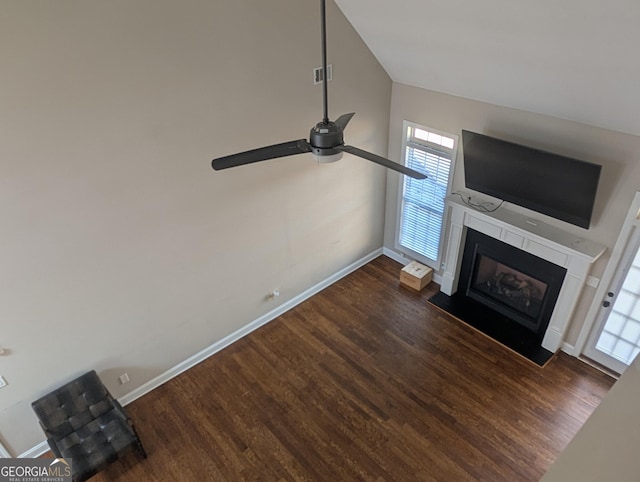 unfurnished living room featuring visible vents, a fireplace with flush hearth, a ceiling fan, wood finished floors, and baseboards