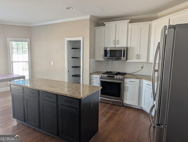 kitchen with dark wood-style floors, appliances with stainless steel finishes, white cabinets, and crown molding