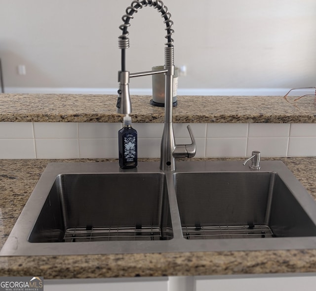 details featuring a sink, white cabinetry, and light stone countertops