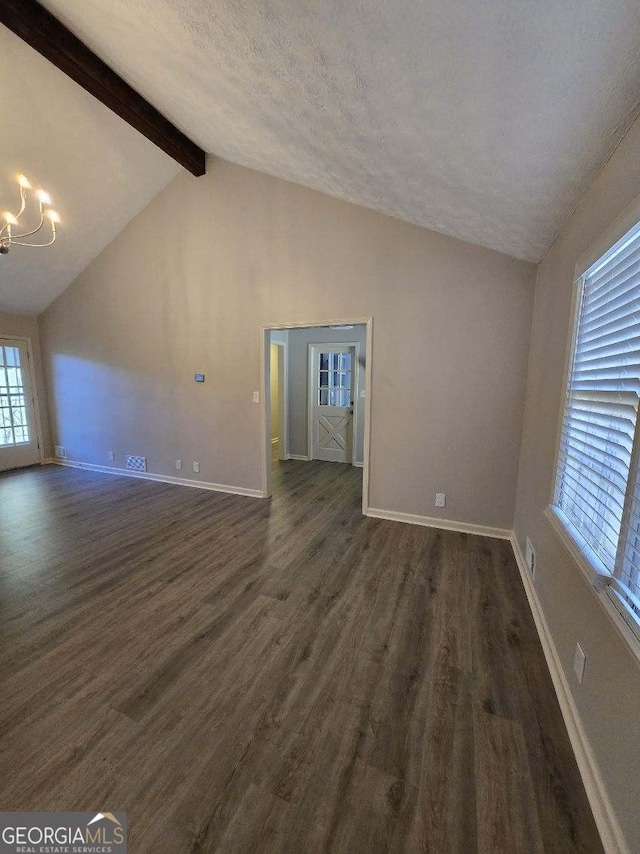 unfurnished living room featuring lofted ceiling with beams, a textured ceiling, a chandelier, baseboards, and dark wood-style floors