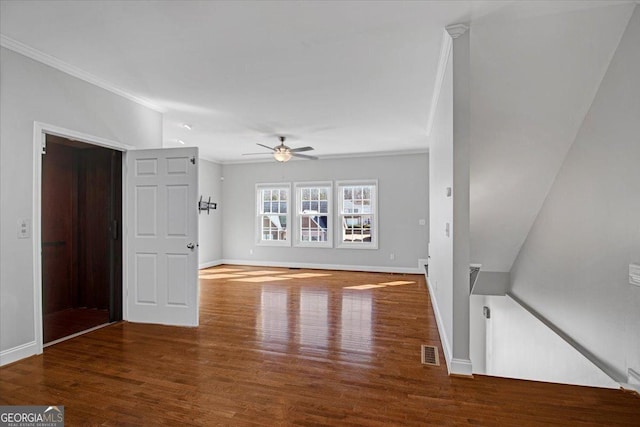 unfurnished living room featuring baseboards, crown molding, visible vents, and wood finished floors