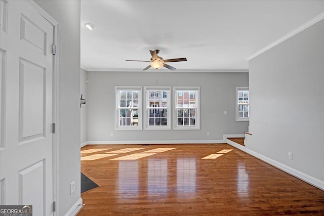 unfurnished living room featuring ornamental molding, ceiling fan, baseboards, and wood finished floors