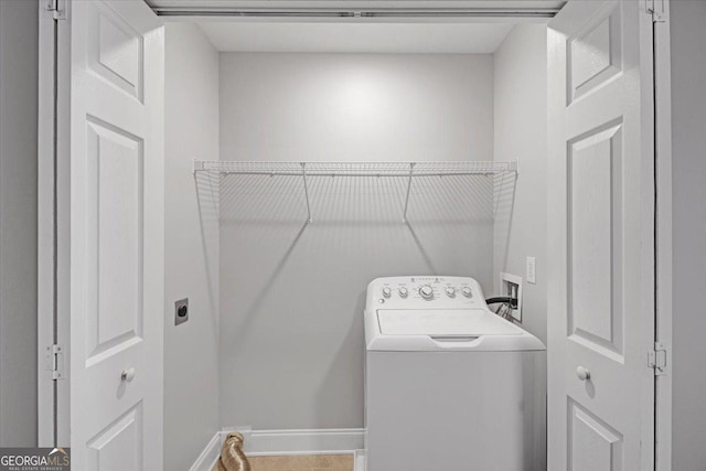 washroom featuring laundry area, washer / dryer, and baseboards