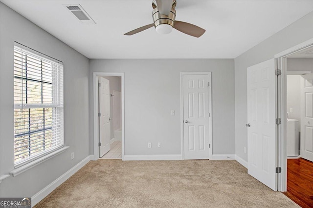 unfurnished bedroom featuring carpet, visible vents, ceiling fan, ensuite bath, and baseboards