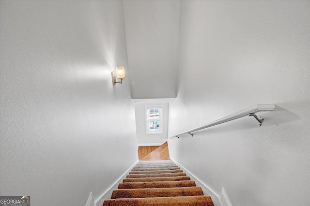 stairway with baseboards and wood finished floors