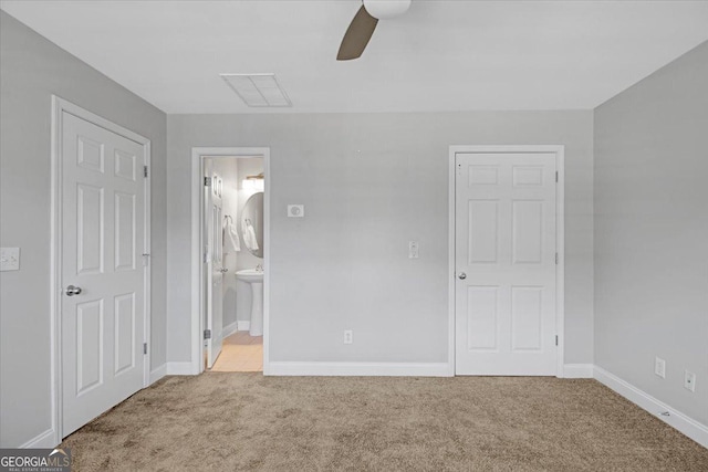 unfurnished bedroom with ceiling fan, visible vents, baseboards, carpet, and ensuite bath