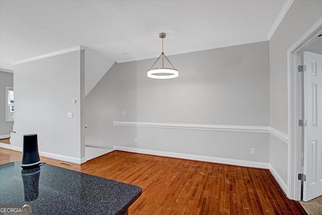 dining room with visible vents, baseboards, crown molding, and wood finished floors