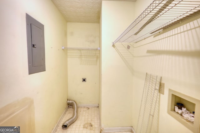 laundry area featuring laundry area, electric panel, baseboards, hookup for an electric dryer, and a textured ceiling