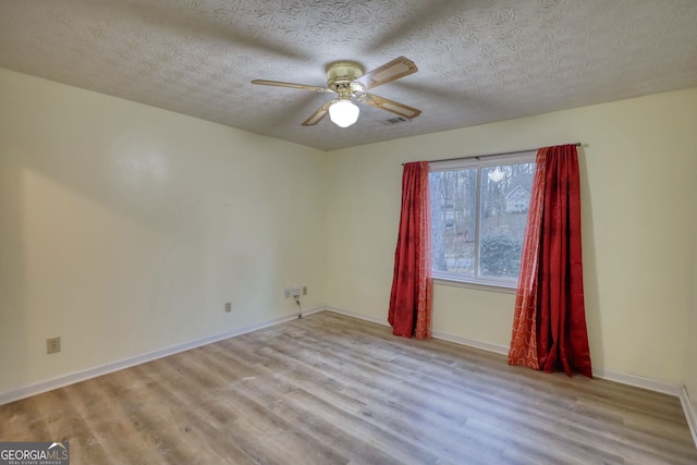 spare room with baseboards, a textured ceiling, a ceiling fan, and wood finished floors