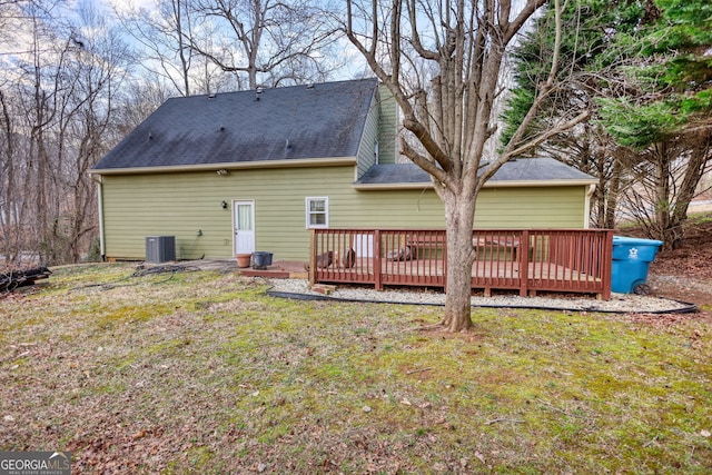 back of house with cooling unit, roof with shingles, a lawn, and a deck