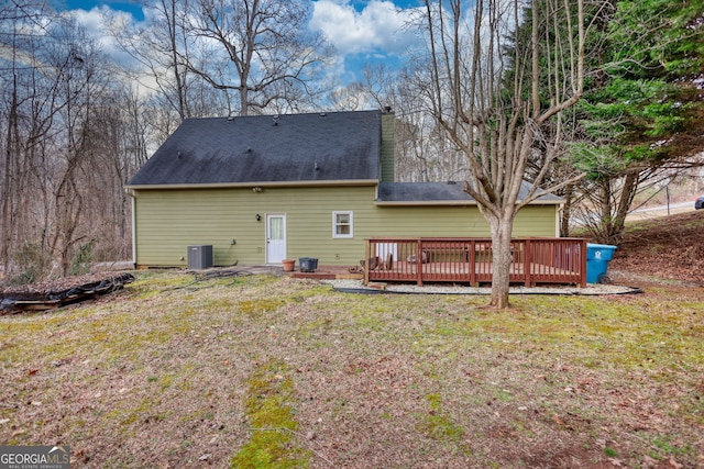 rear view of property with a yard, central AC, and a wooden deck