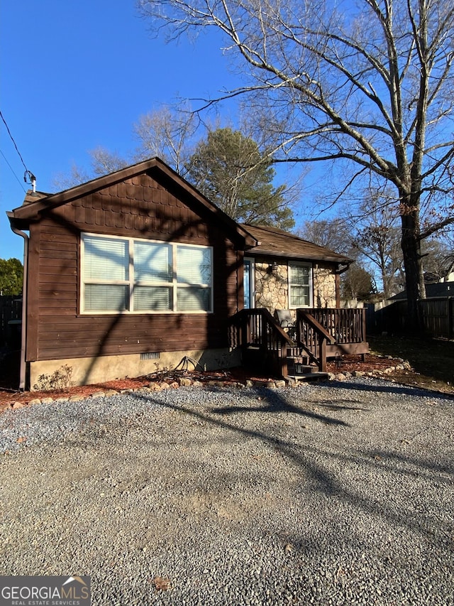 view of front of house featuring crawl space and fence