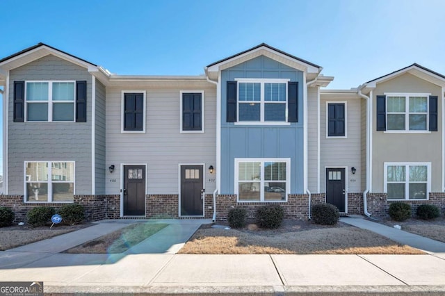 townhome / multi-family property with board and batten siding and brick siding