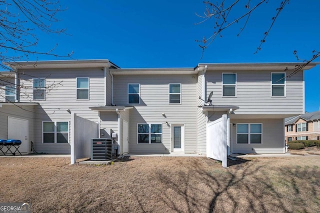 rear view of property with cooling unit and a yard