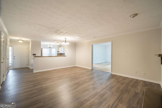 unfurnished living room featuring ornamental molding, dark wood-type flooring, a textured ceiling, and an inviting chandelier