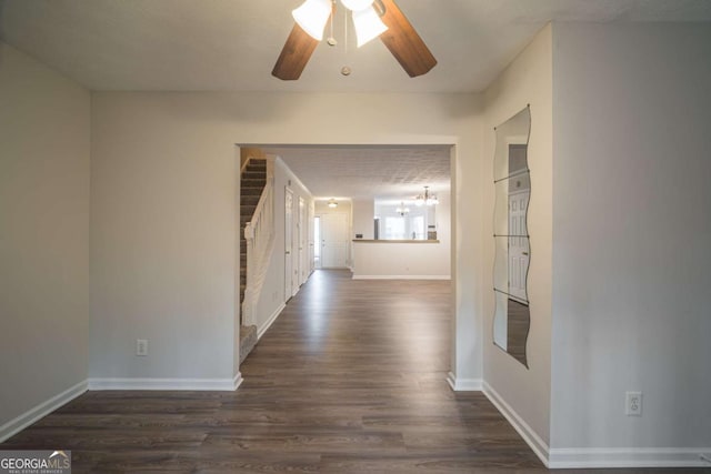 hall with dark wood-style flooring and baseboards