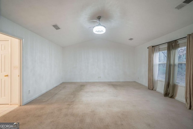 spare room featuring lofted ceiling, baseboards, visible vents, and carpet flooring