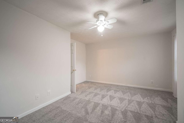 unfurnished room featuring visible vents, a ceiling fan, carpet flooring, a textured ceiling, and baseboards