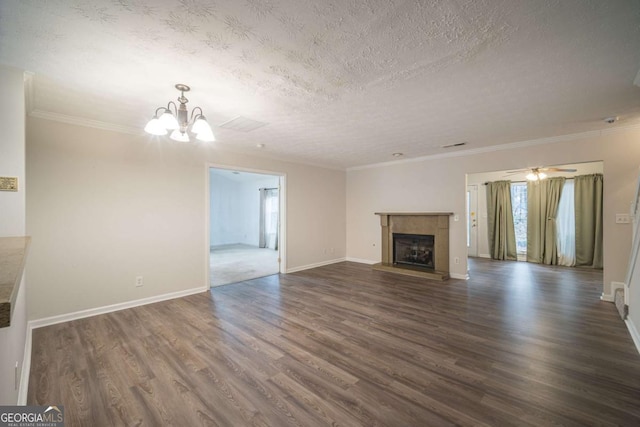 unfurnished living room with a textured ceiling, a fireplace with raised hearth, dark wood-style floors, an inviting chandelier, and crown molding