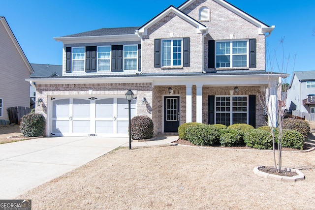 traditional-style house with a garage, concrete driveway, and brick siding