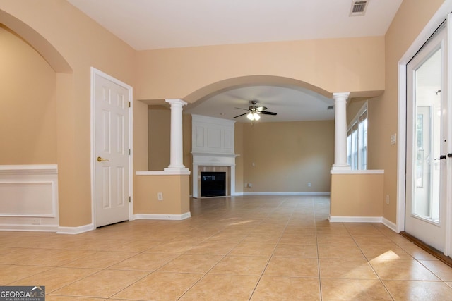 unfurnished living room with light tile patterned floors, baseboards, visible vents, a ceiling fan, and ornate columns