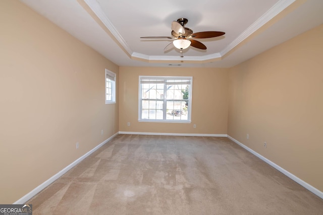 unfurnished room featuring ornamental molding, a raised ceiling, light carpet, and baseboards