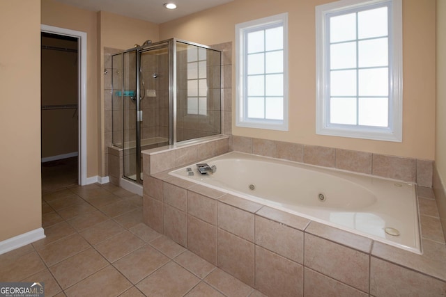 full bathroom featuring baseboards, a whirlpool tub, tile patterned flooring, a spacious closet, and a shower stall