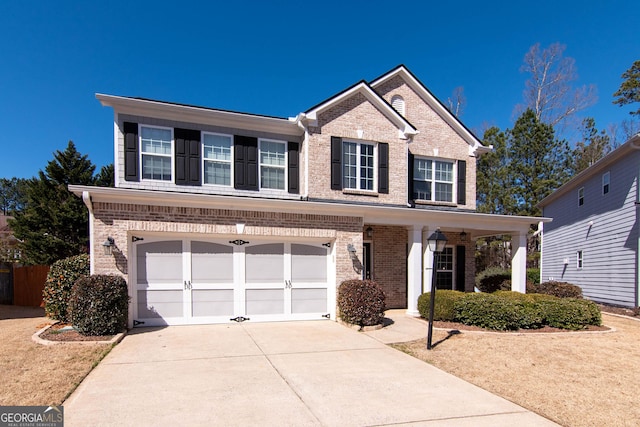 view of front of property featuring a garage, concrete driveway, and brick siding