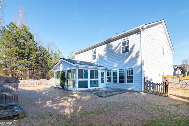 rear view of property with fence private yard and a sunroom