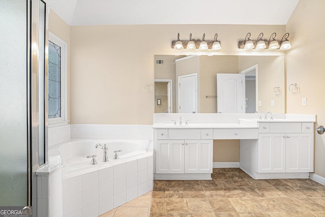 full bath featuring a garden tub, a sink, visible vents, and double vanity