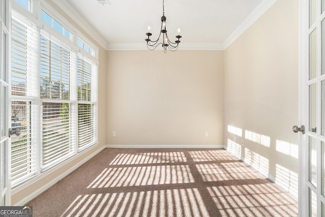 spare room with carpet floors, baseboards, a chandelier, and crown molding