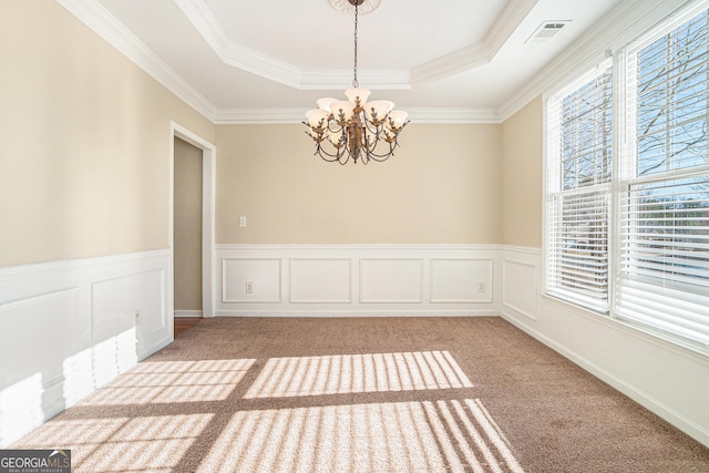 unfurnished room with a notable chandelier, light colored carpet, visible vents, a tray ceiling, and crown molding