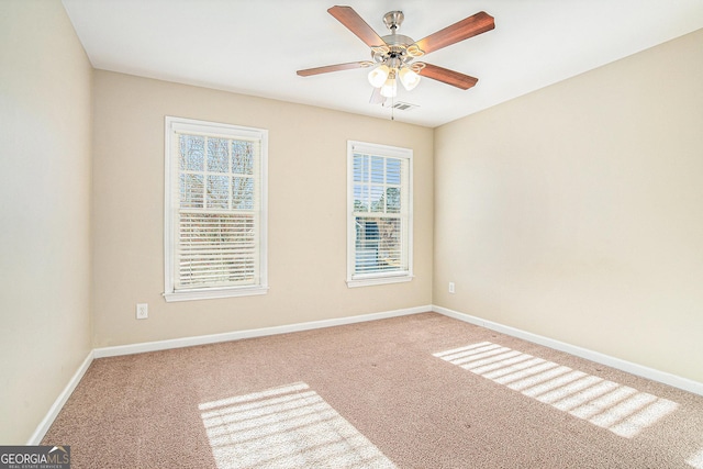 unfurnished room featuring ceiling fan, carpet floors, visible vents, and baseboards