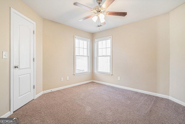 carpeted spare room with baseboards and a ceiling fan