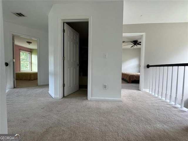 interior space with carpet floors, visible vents, baseboards, and a walk in closet